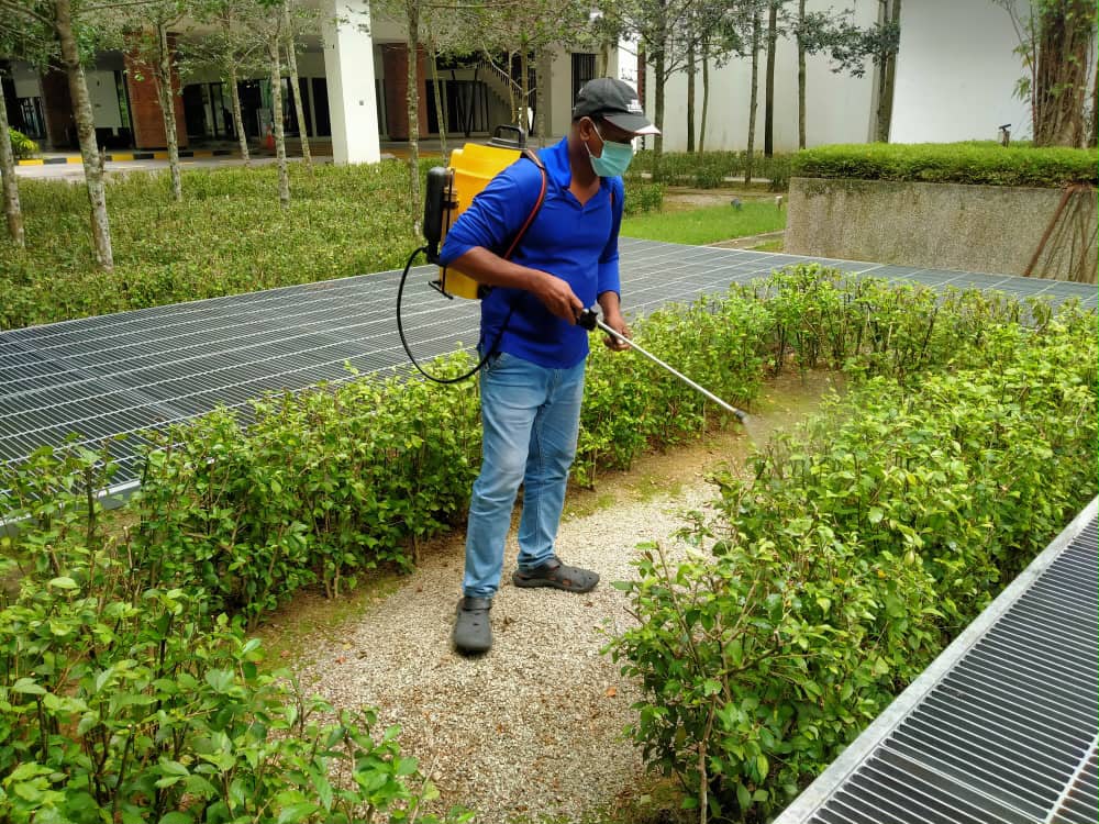 CSC Services crew member spraying garden beds